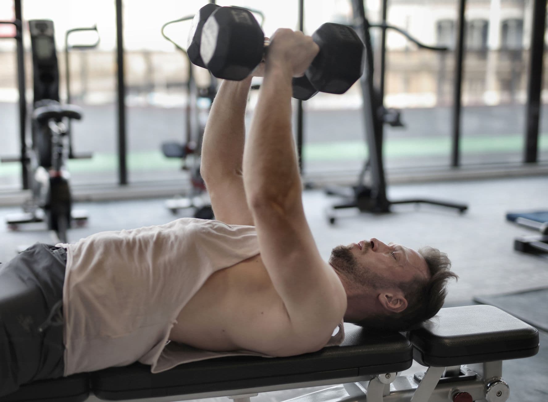 A dumbbell press on a bench in a gym