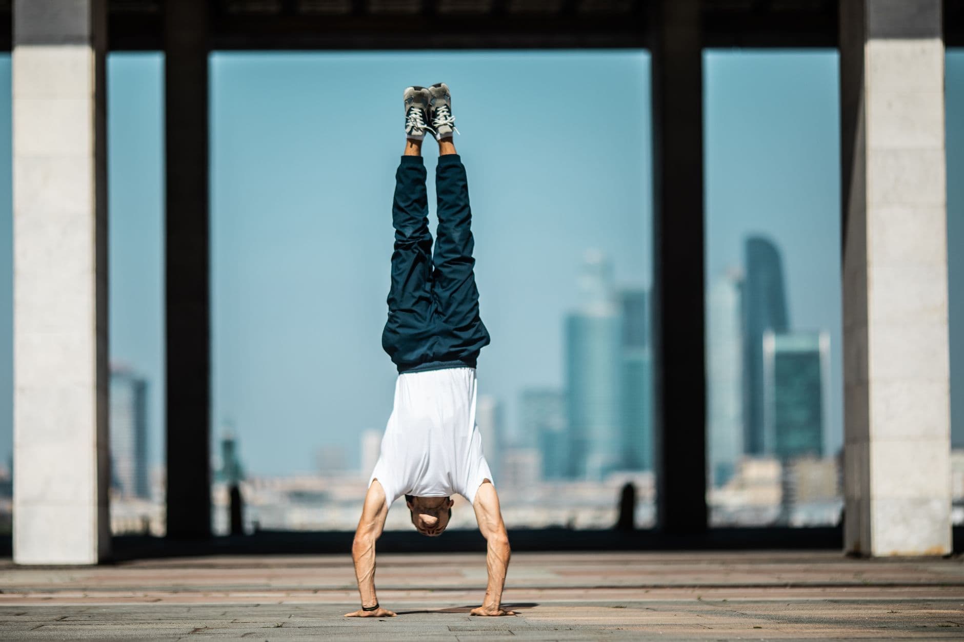 A handstand held in front of tall windows