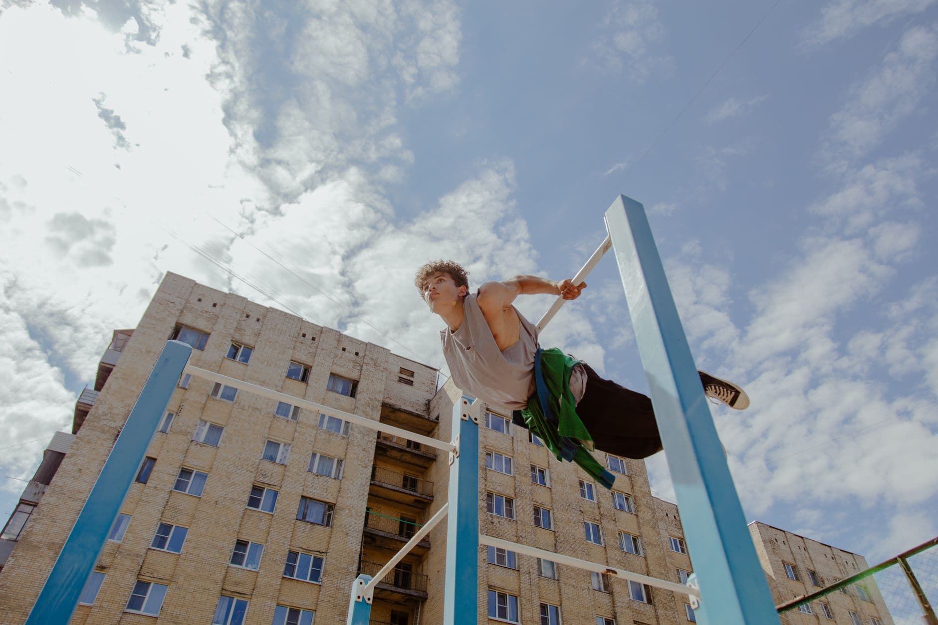 An athlete holding a horizontal position on a vertical bar