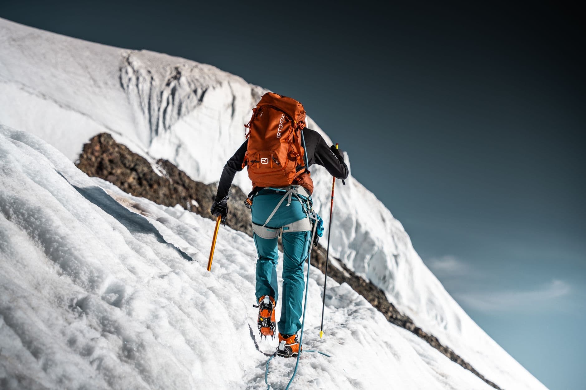 A mountaineer with a pack and an axe on a snow slope