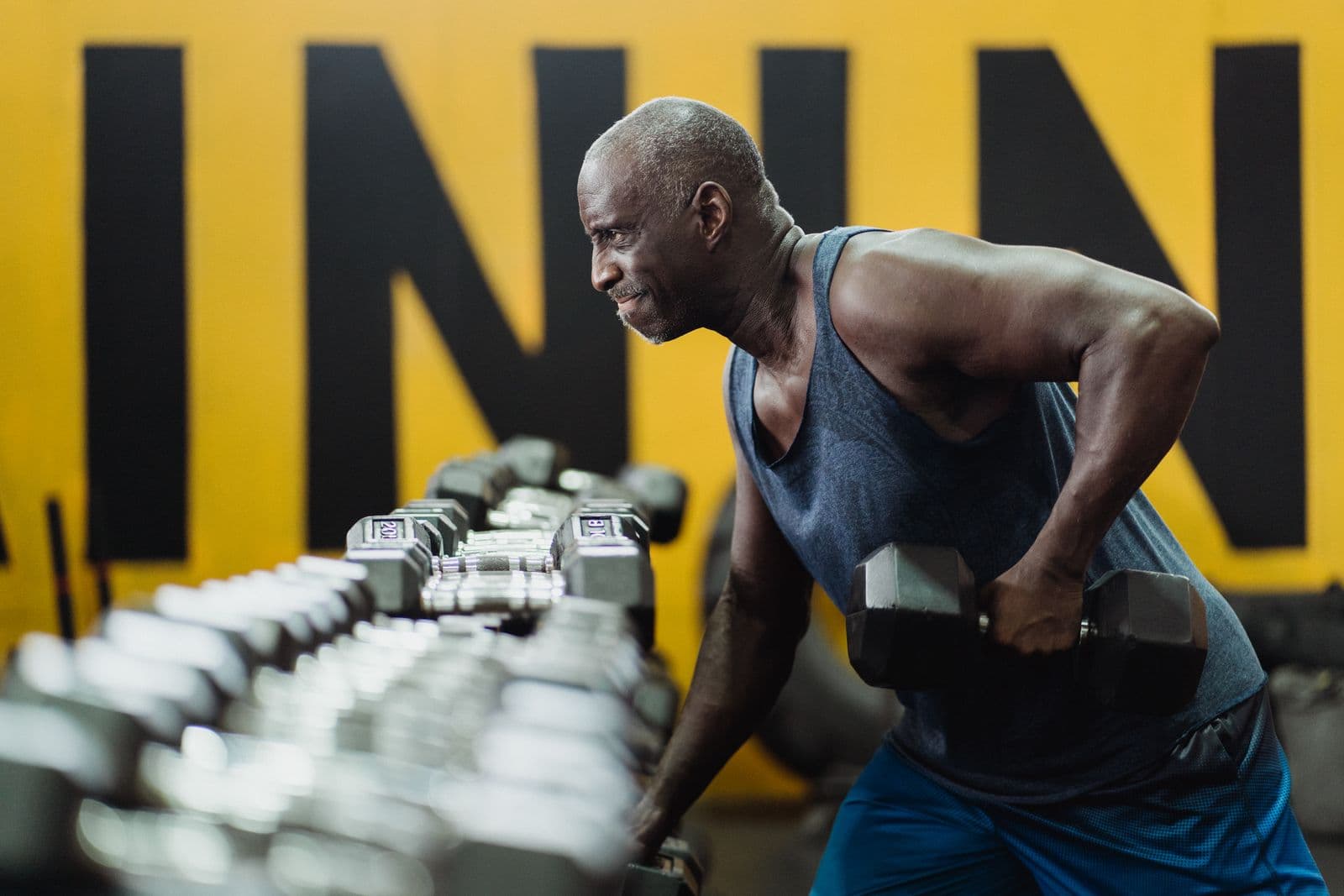 An older man working with dumbbells in a gym