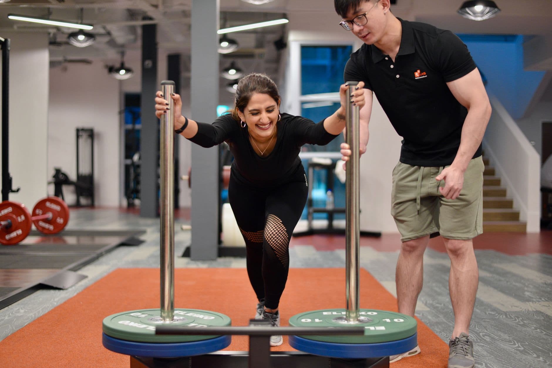 A weighted sled being pushed across a gym floor