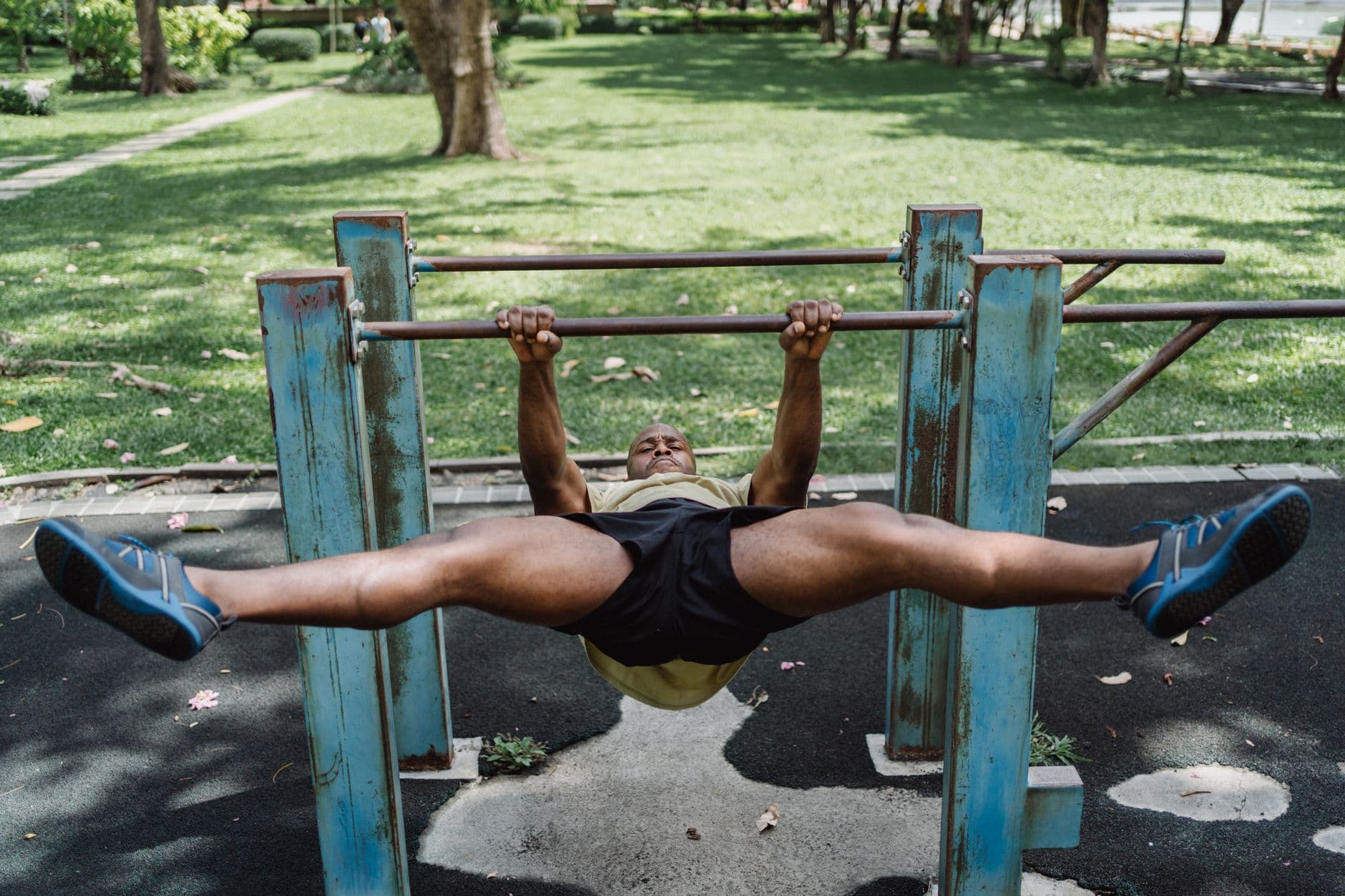 A straight-arm hold on an outdoor calisthenics bar